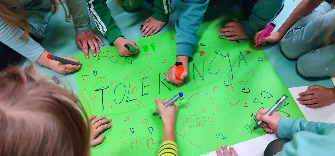 Zdjęcie uczniów robiących plakat o tolerancji