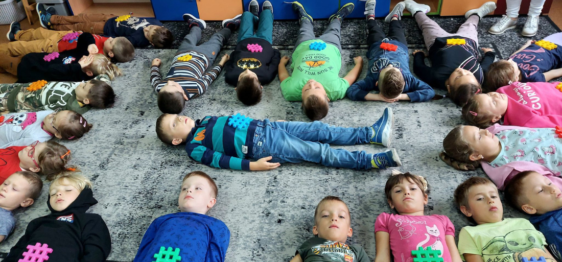 Zdjęcie uczniów leżcych na dywanie
